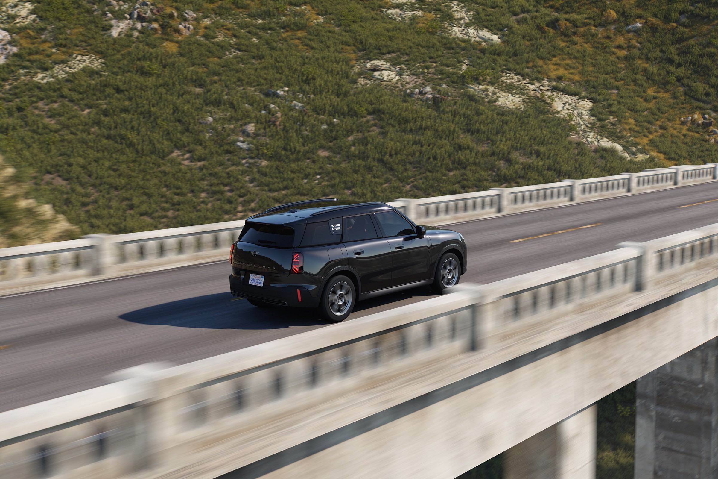 Mini Countryman a atravessar uma ponte, rodeado por paisagem natural 